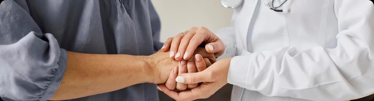 Healthcare provider holding a patient's hands
